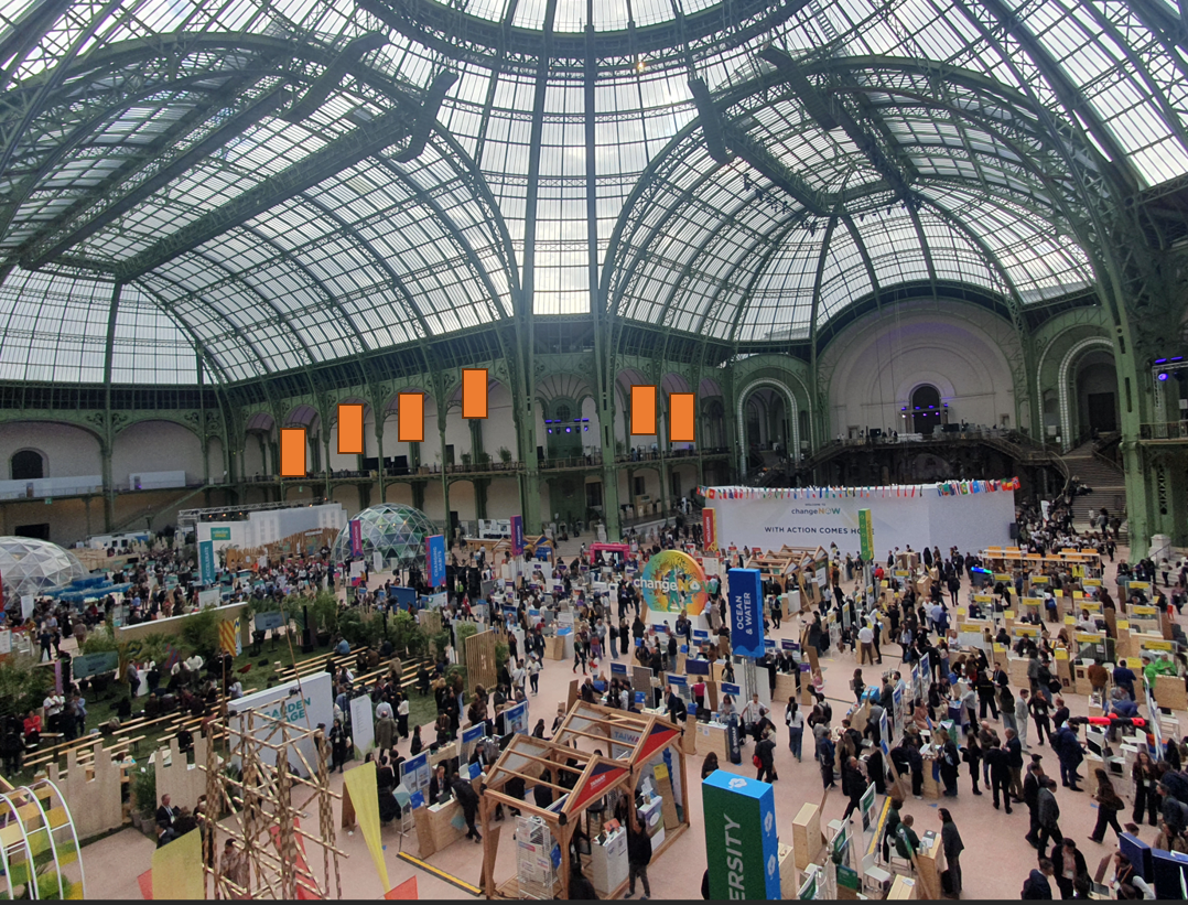Vue de l'exposition de cas d'entreprises presentee au Grand Palais lors de l'evenement ChangeNow : panneaux verticaux et allees de visiteurs.